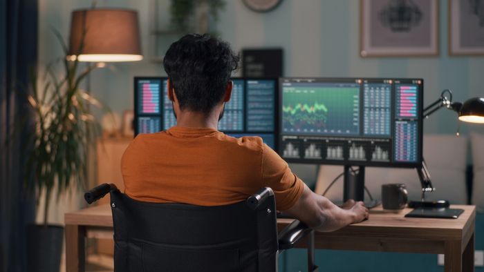 Someone doing their own stock research at home on multiple screens.