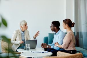 A financial advisor meeting with a smiling couple